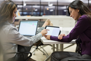 two women looking at screens