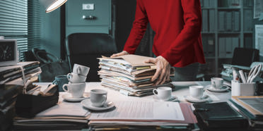 person holding stack of papers