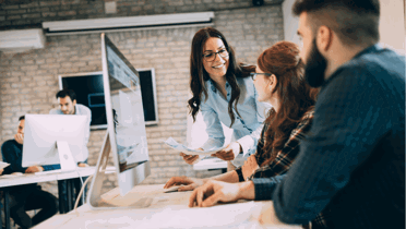 modern open office with three people discussing by computer