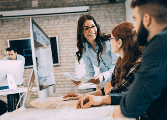modern open office with three people discussing by computer
