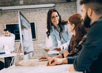 modern open office with three people discussing by computer