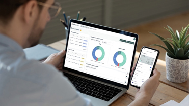 Un homme utilisant Medius Expense sur son ordinateur et son appareil mobile