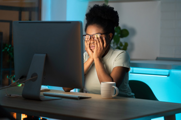 woman working late, rubbing her eyes
