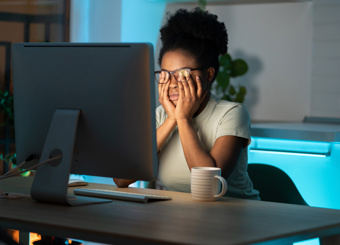 woman working late, rubbing her eyes