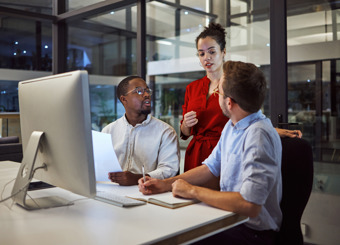 three people talking in office at evening