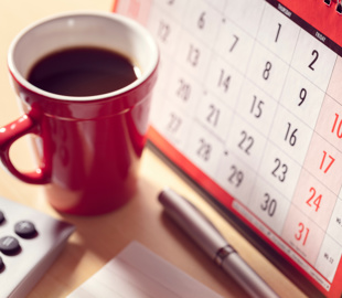 Paper calendar and cup of coffee
