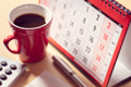 Paper calendar and cup of coffee