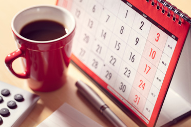 Paper calendar and cup of coffee