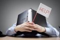 Person holding laptop to their face with a "Help!" sign