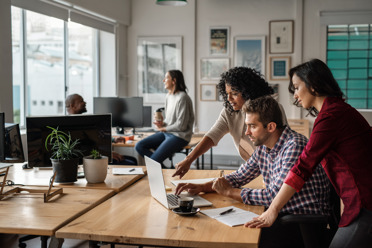 five people working in a small office landscape